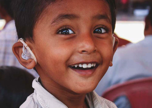 smiling boy with hearing aid